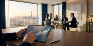 Un professionnel examine des graphiques financiers sur une tablette avec la tour Eiffel en arrière-plan.